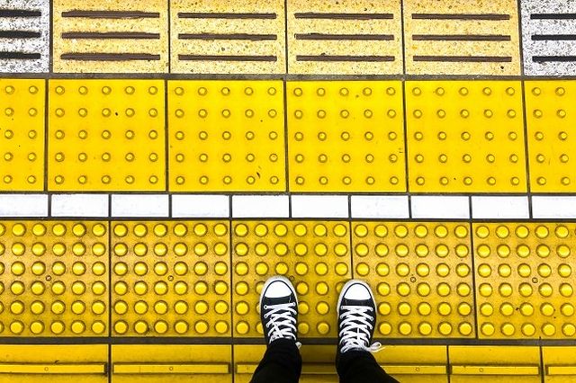 駅のホーム端にはホームの内側と外側が区別できるように点状ブロックに加えて1本線の突起がホーム内側についている