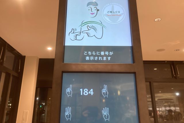 コーヒーなどの飲食物はレシートに記された呼び出し番号がデジタルサイネージに表示されることで教えてくれる
